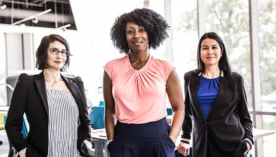 trois femmes debout dans une pièce bien éclairée