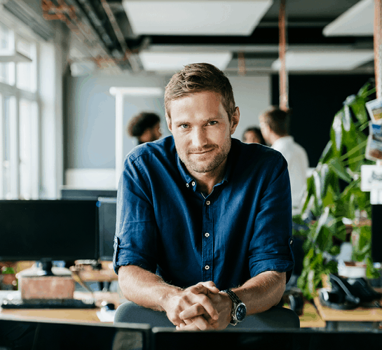 entrepreneur dans un bureau, appuyé sur son bureau