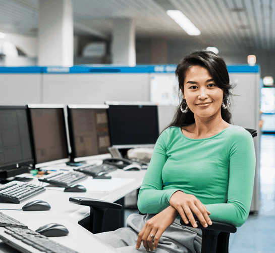 femme souriante devant plusieurs écrans d'ordinateur