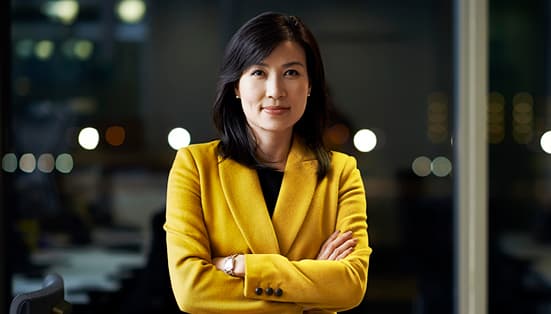 femme entrepreneur dans un blazer jaune regardant droit devant avec confiance