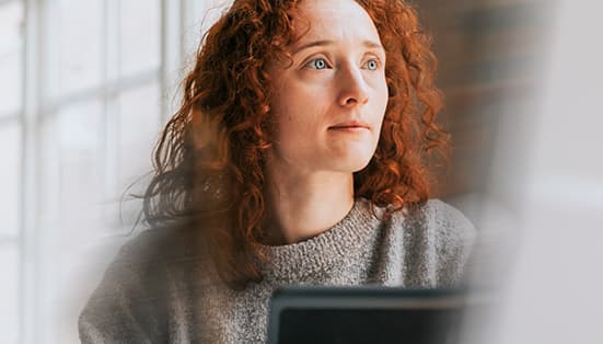 femme rousse assise au bureau avec ordinateur