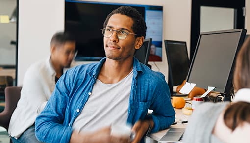Travailleur informatique s'appuyant sur son bureau avec un café
