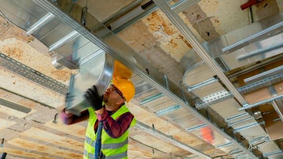 travailleur de la construction changeant une pièce du système de chauffage
