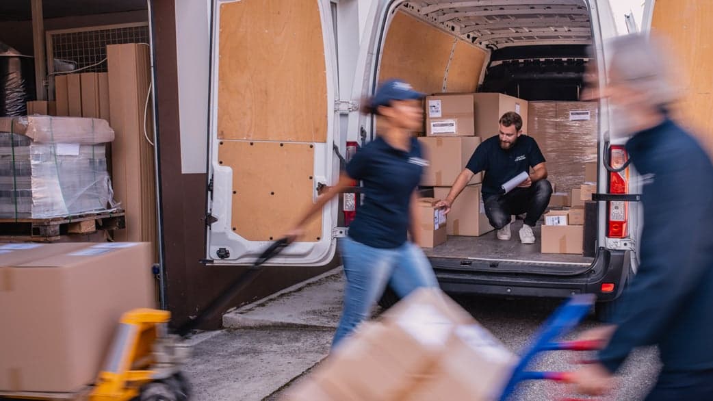 un homme et une femme déplacent des cartons pour charger un camion