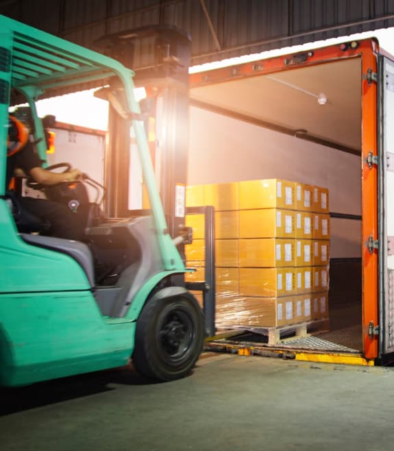 chariot élévateur déposant des boîtes dans un camion