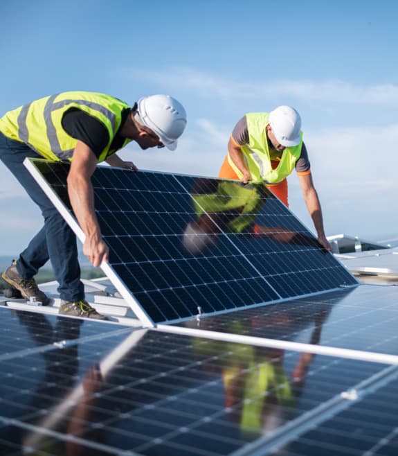 deux hommes installant un panneau solaire sur un toit