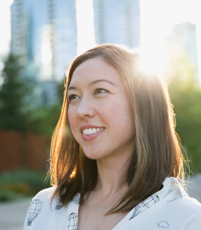 jeune femme souriante, le soleil brille derrière elle